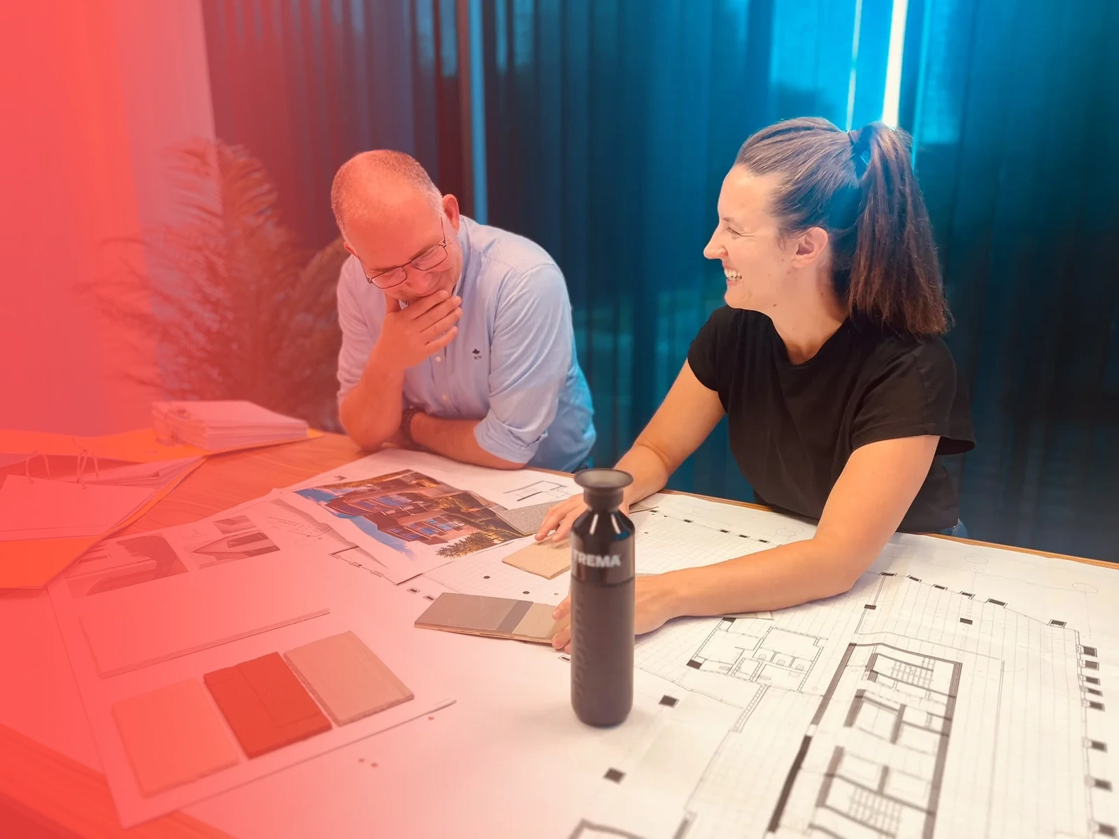 Trema collega's in overleg op kantoor met bouwplannen en Trema drinkfles