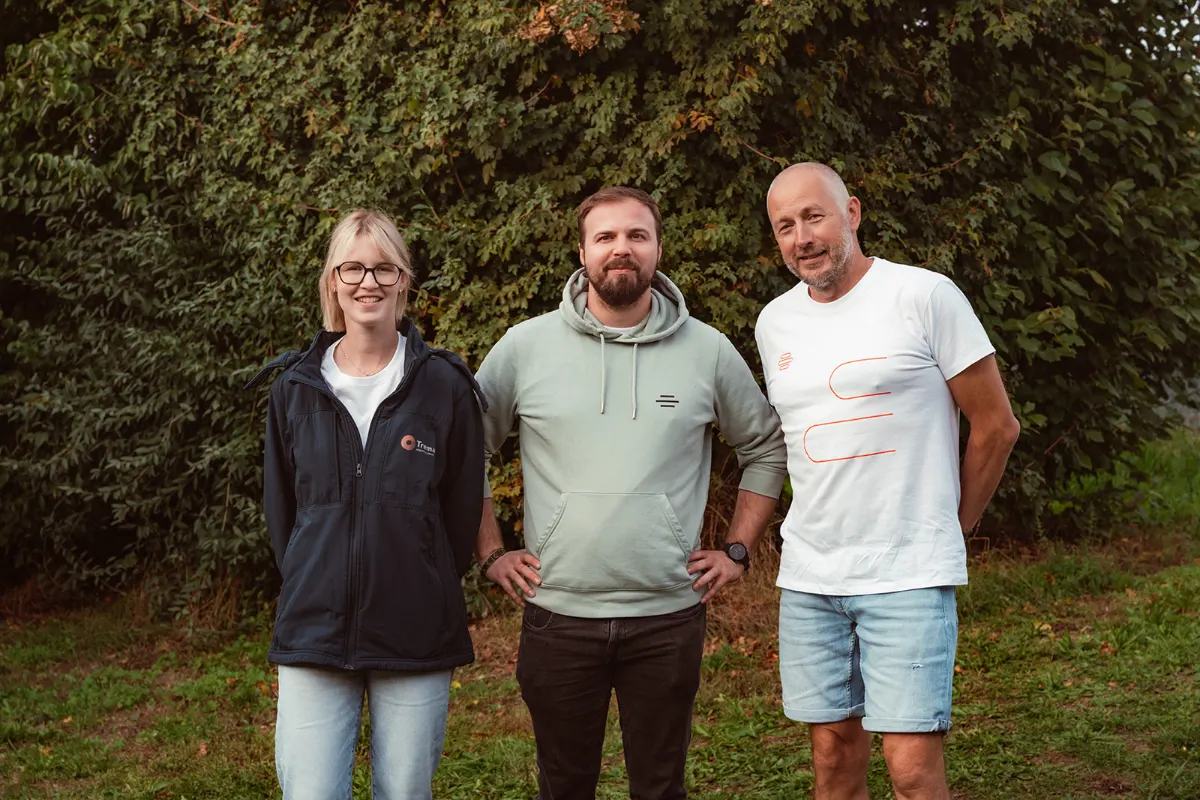 Drie collega's van Trema in de kledij van drie generaties Trema-branding